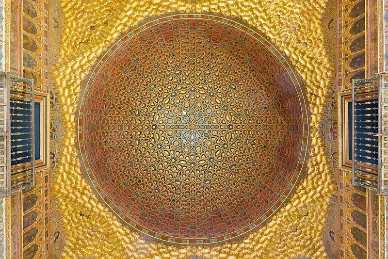 A gilded wooden dome inside the Real Alcázar, seen from directly below.