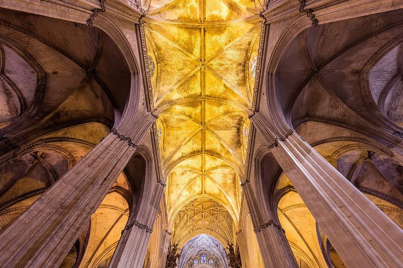 The vaults of Seville Cathedral, which holds the tomb, seen from below.